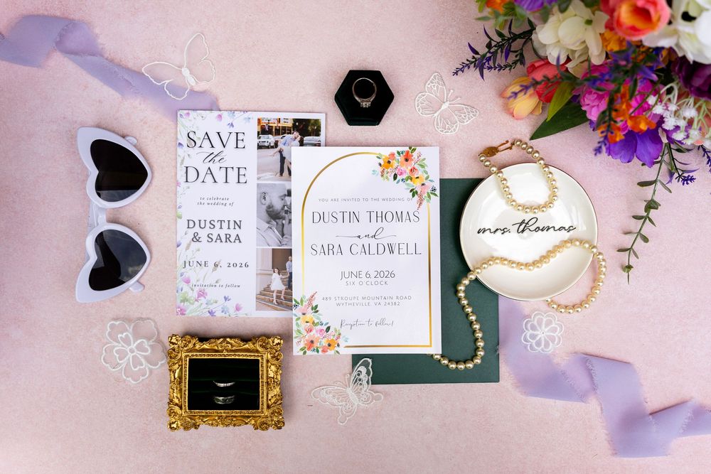 Wedding stationery flatlay featuring save the date, invitations, pearl jewelry, and ring for Dustin and Sara Thomas.