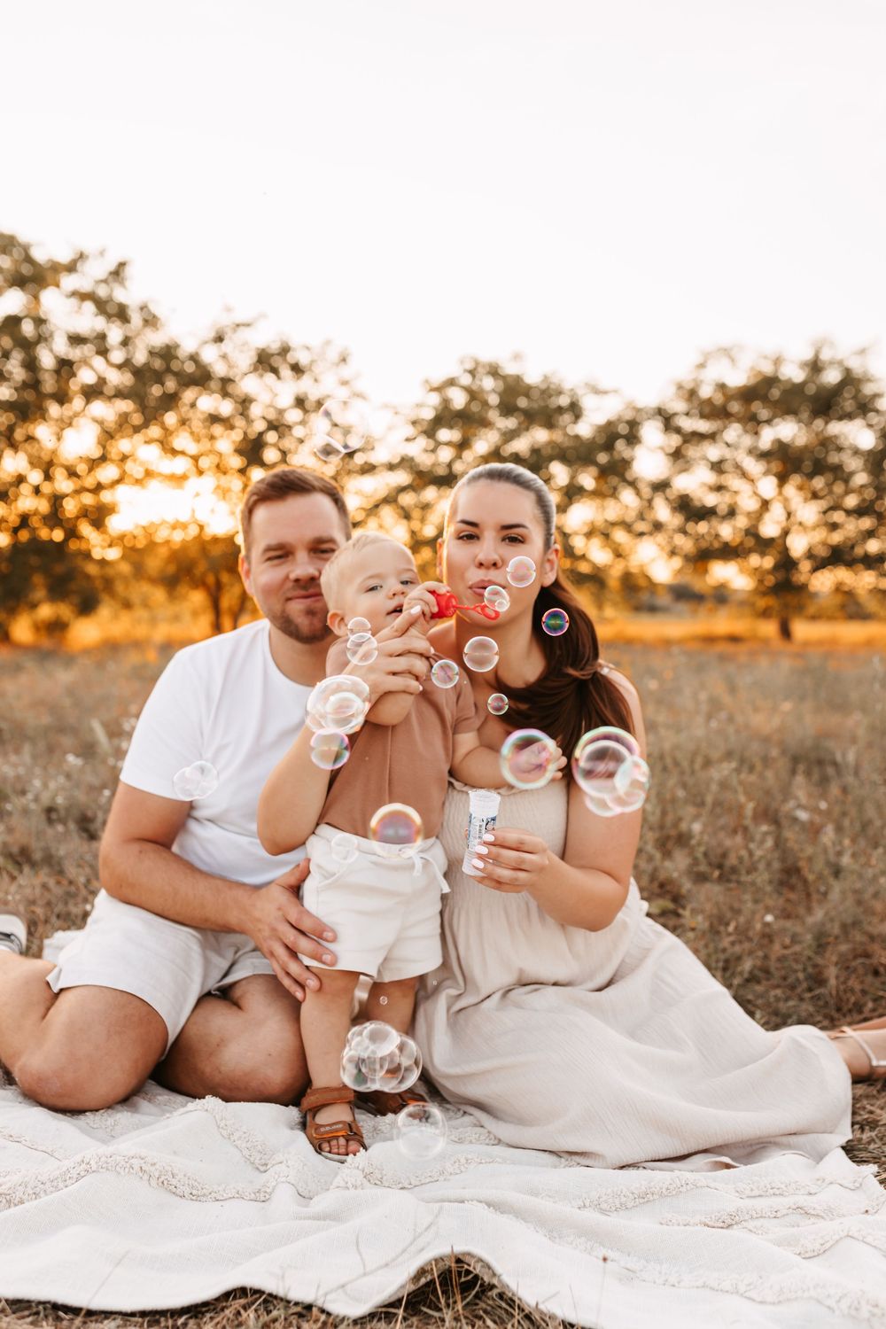 családi lifestyle fotózás egy évessel a naplementében egy buborékfújóval