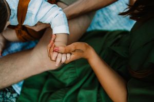 Close-up of parents holding their newborn baby's tiny hand, a tender family bonding moment.