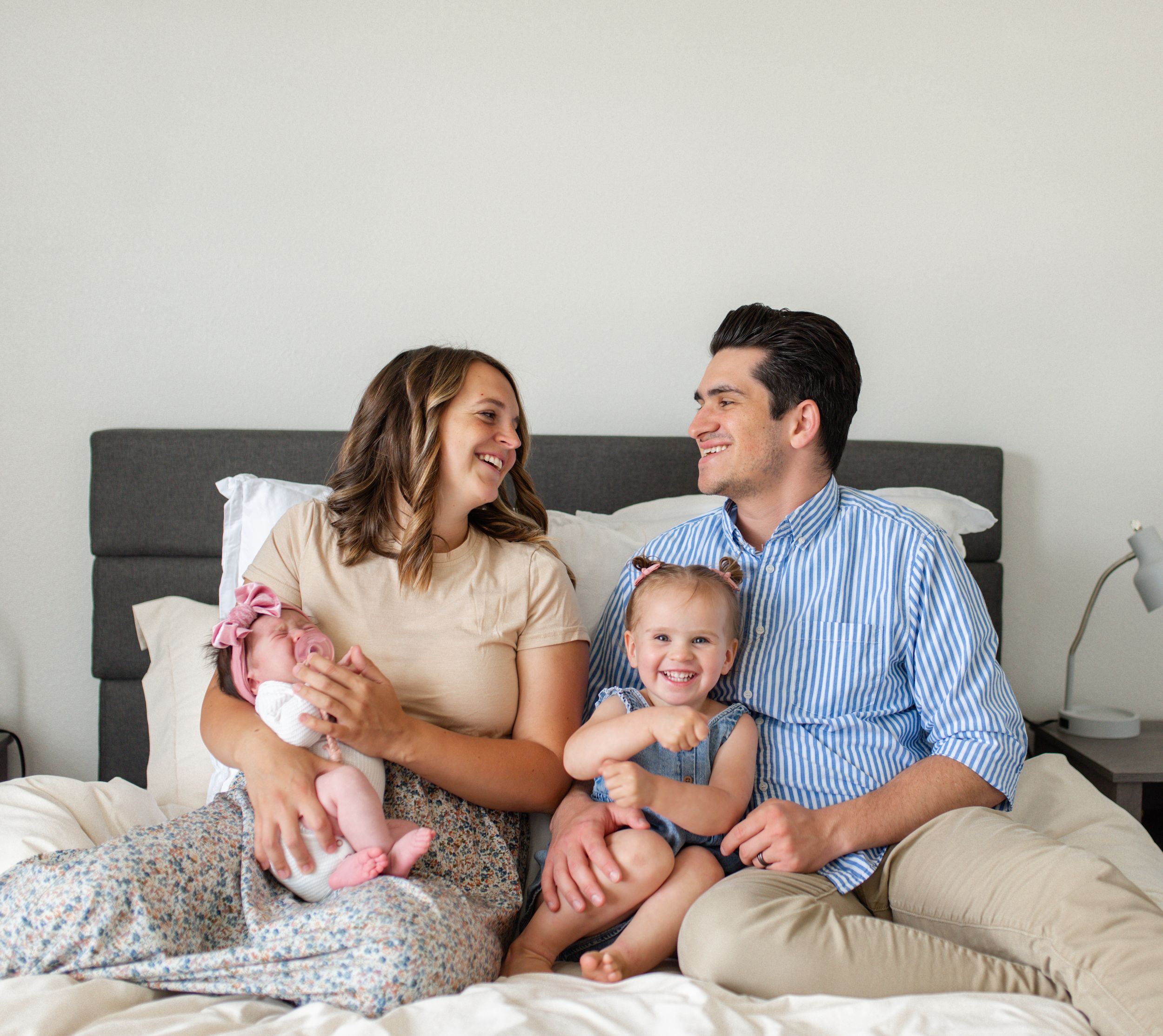 Lifestyle newborn photography in O'Fallon MO showing a family cuddling on their master bedroom