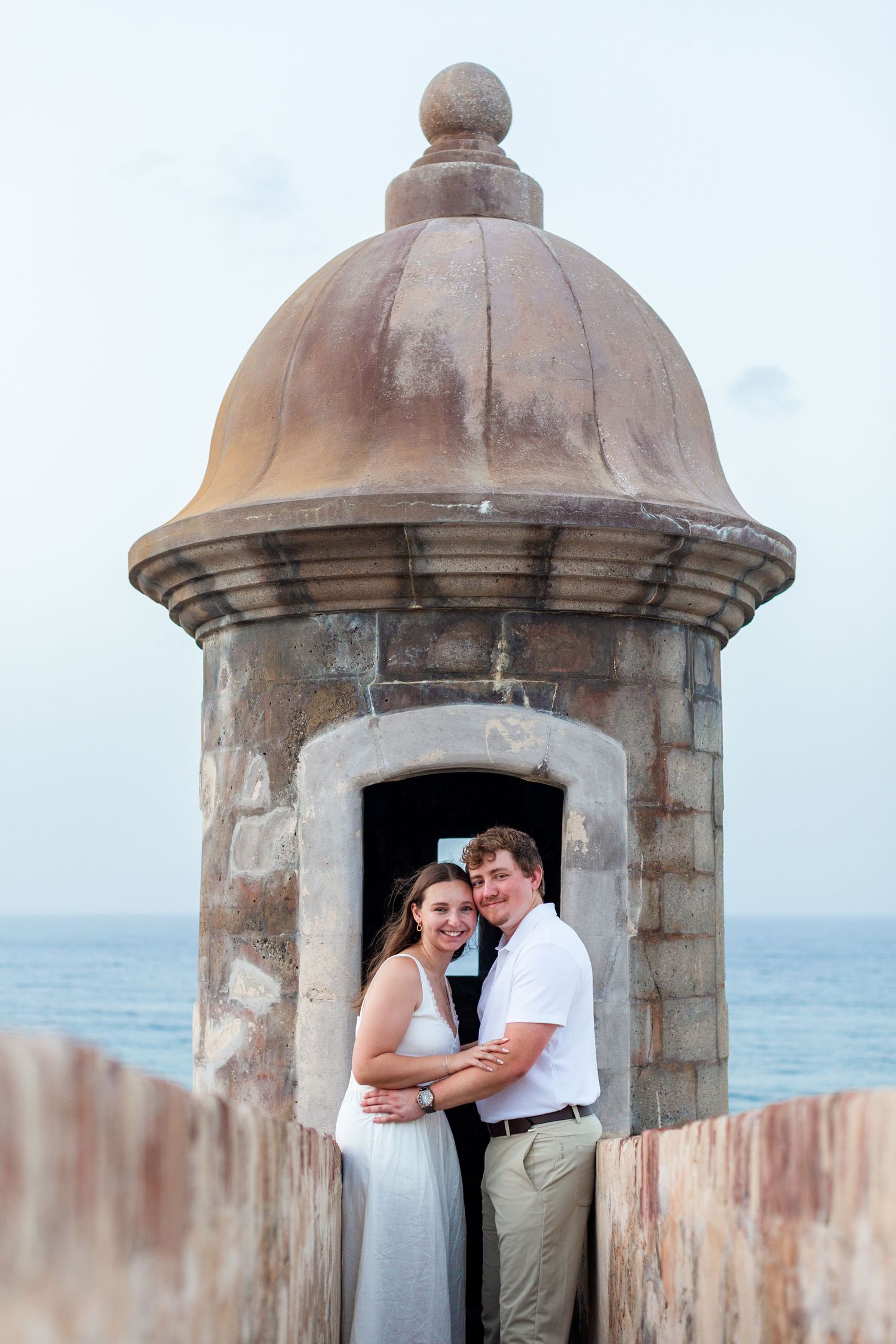 Couples portrait in a garita of the fortress walls. Engagement photo session in Old San Juan, Puerto Rico.