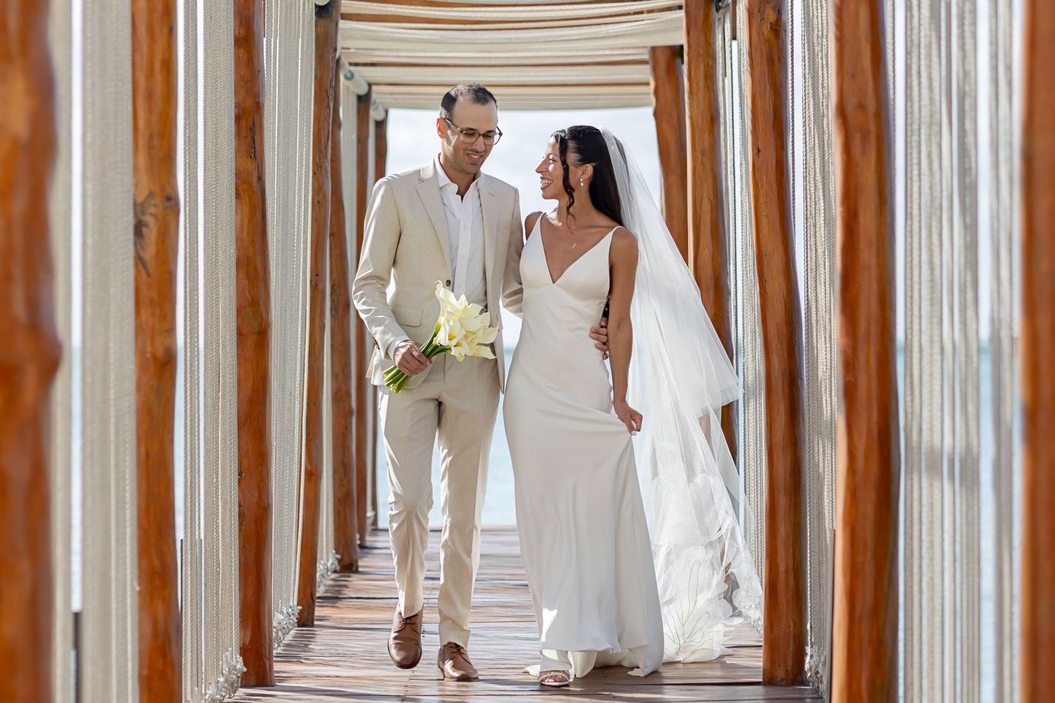 Rebecca and Jason walking together at Ilios Cancun during their Jewish wedding in Cancun.