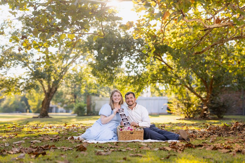 Family portrait session in park with golden sunlight filtering through autumn trees.