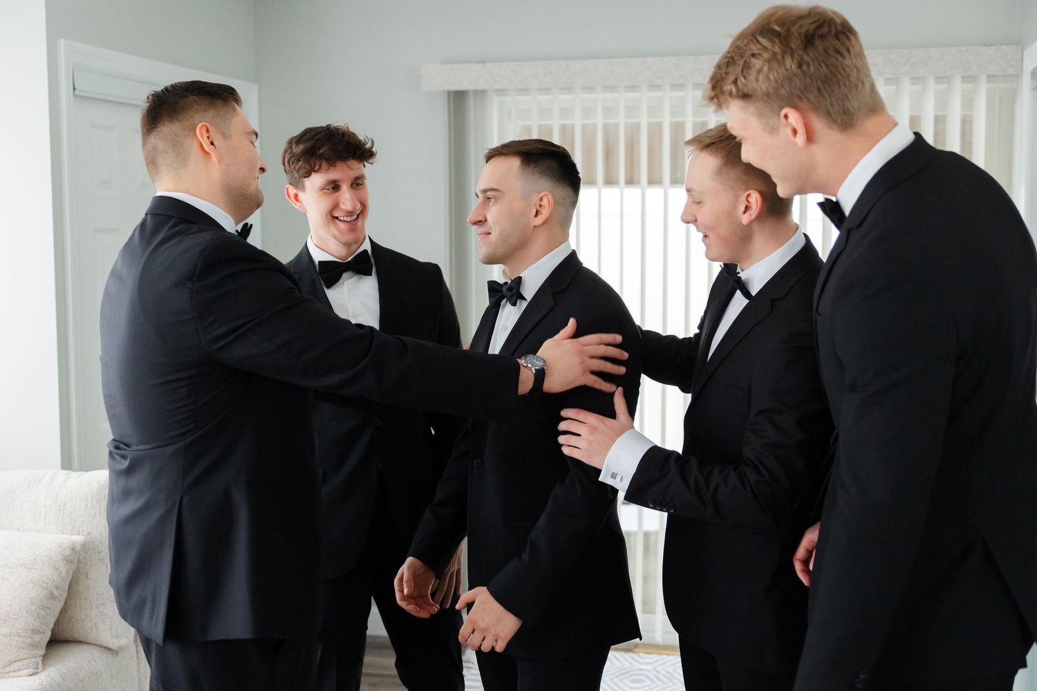 Groomsmen helping groom get ready captured by Tom Forrest Photography from Hudson, Ohio.