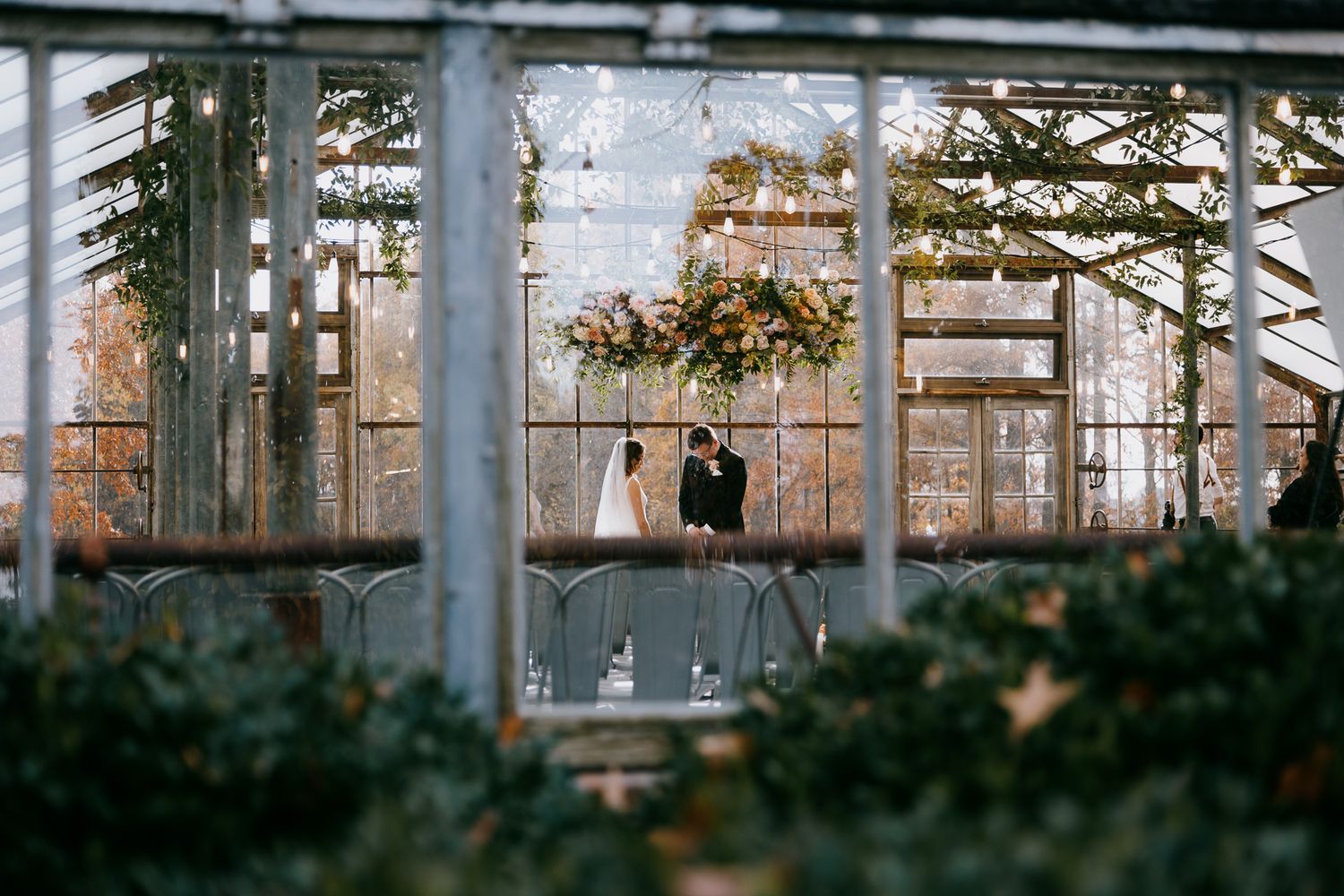 Bride and Groom's intimate first look in a greenhouse framed by windows at Jorgensen Farms, Columbus Ohio, by Cleveland wedding photographer