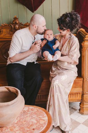 Family sharing tender moments together on a vintage wooden bed with pink bedding.