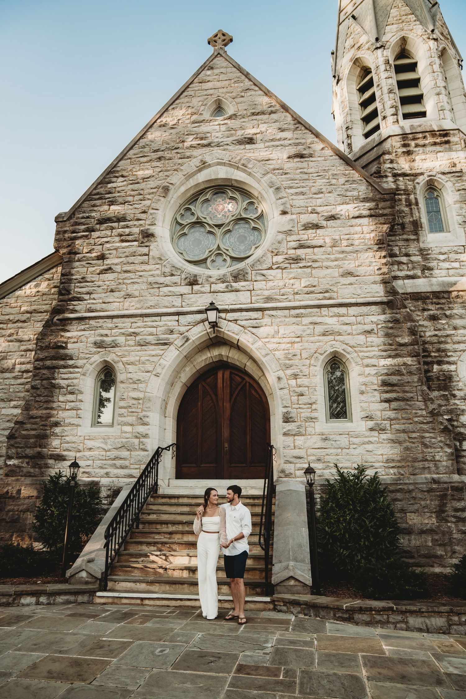 Gothic stone church exterior with arched doorway and stained glass windows.