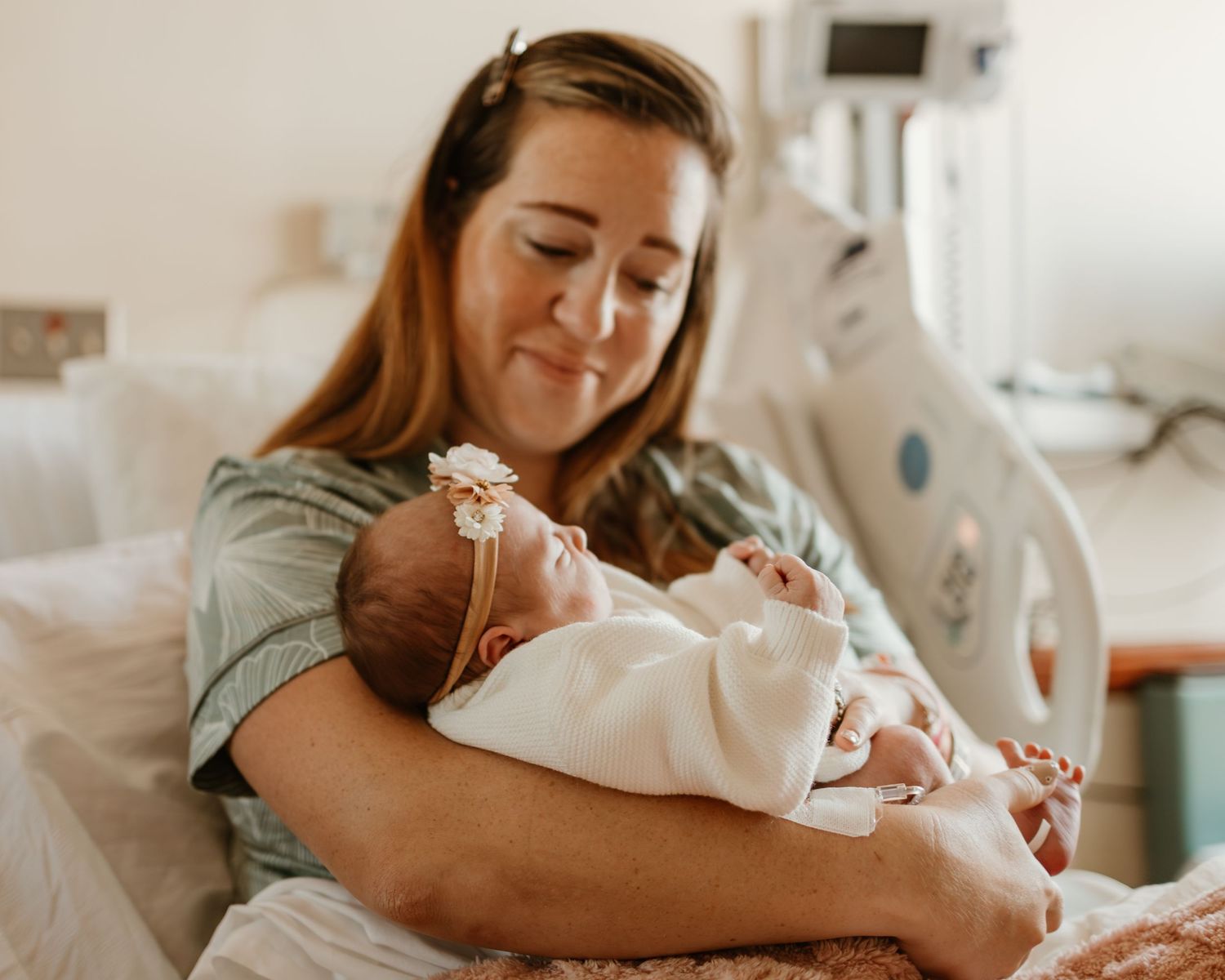 Intimate hospital room scene with new parents and baby.