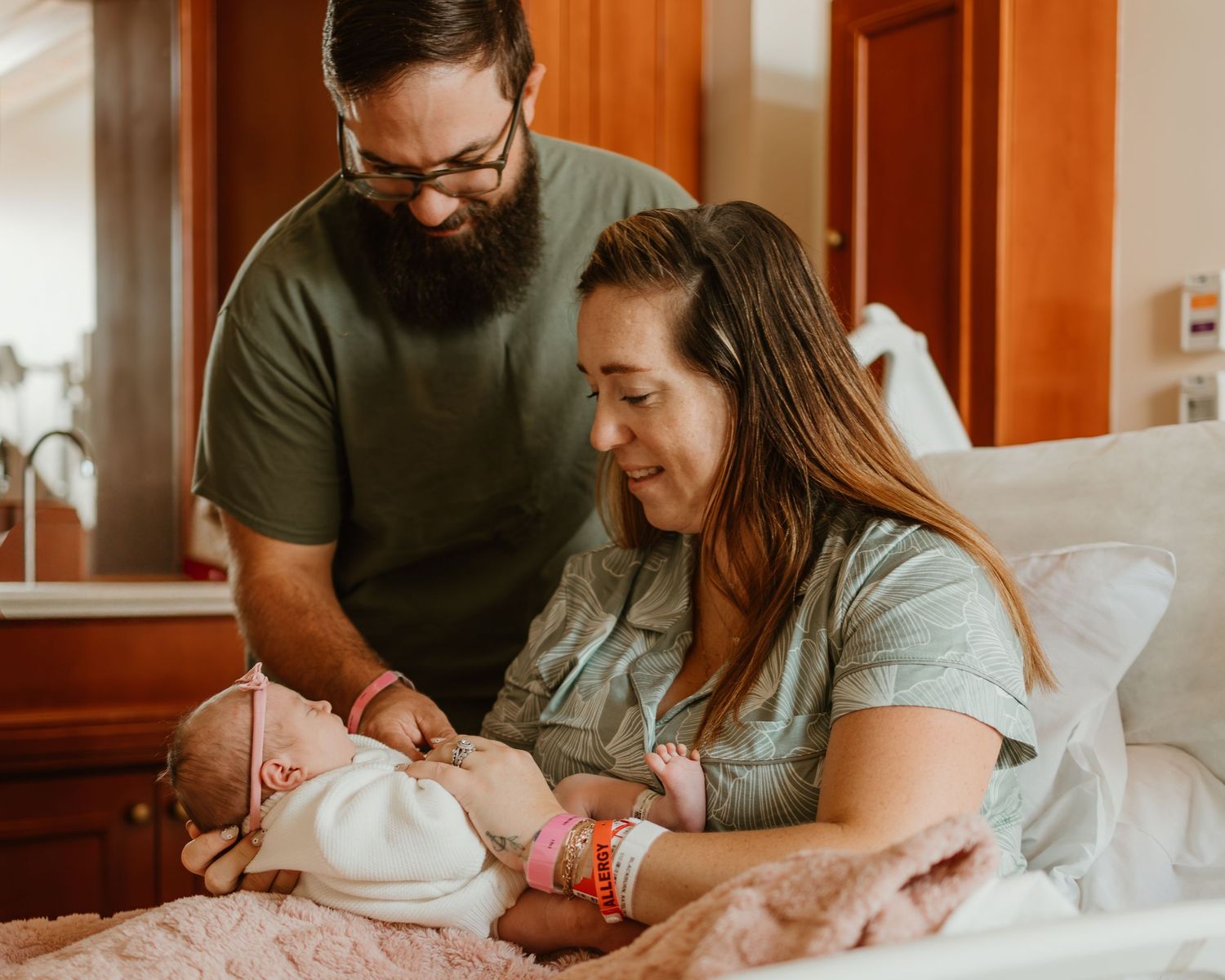 Family gathers around hospital bed to welcome new arrival.