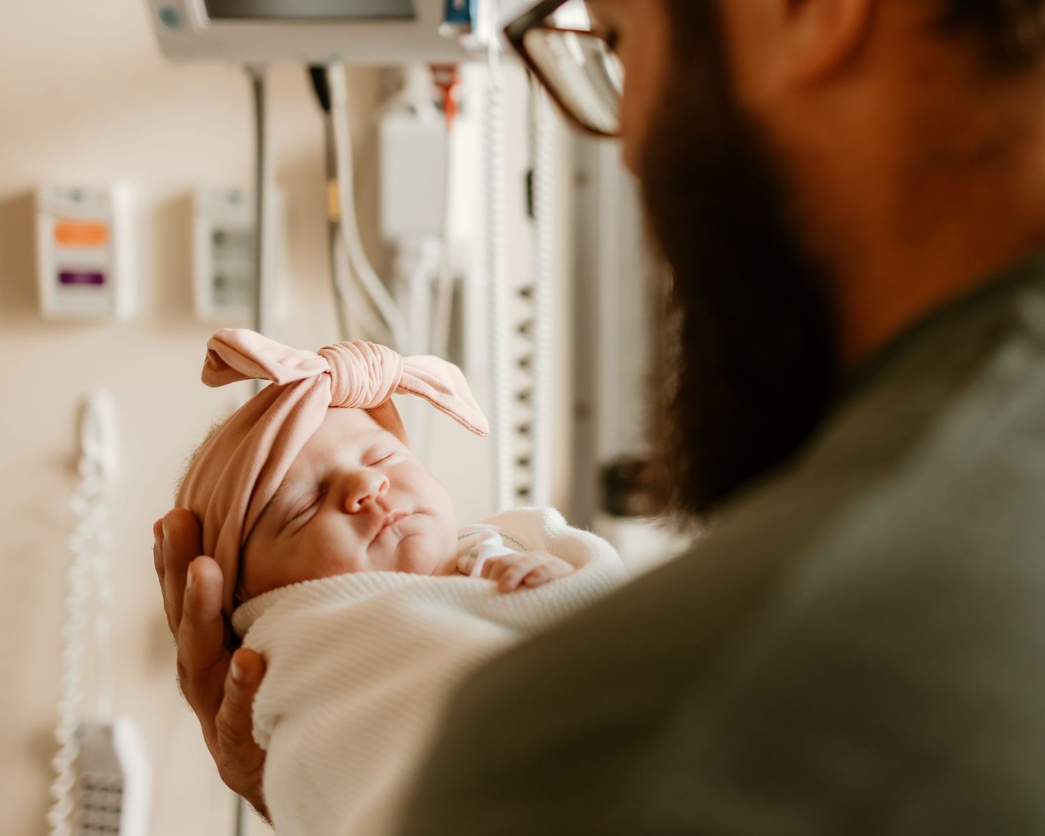 Close-up view of sleeping newborn in hospital setting.