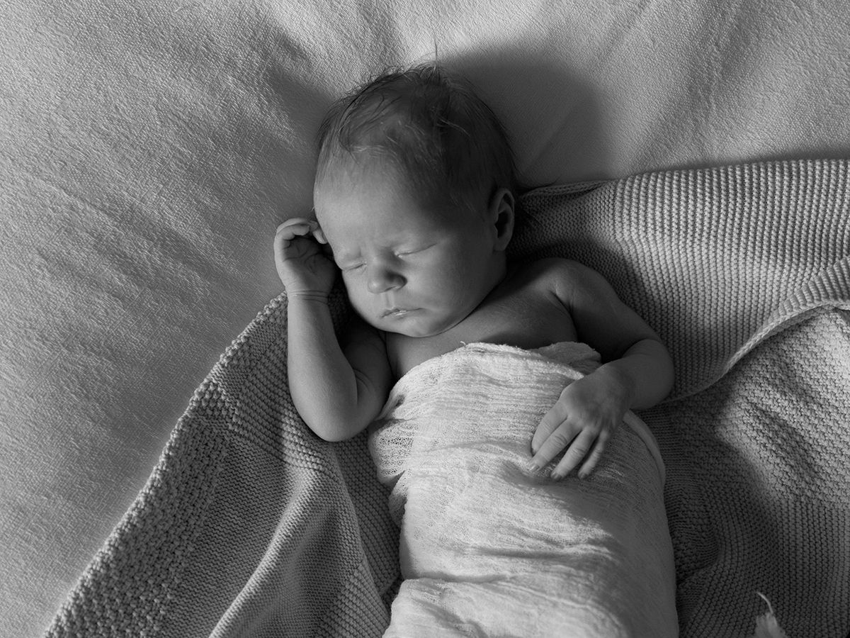 A sleeping baby lies peacefully on a soft gray blanket in various positions showing different angles.