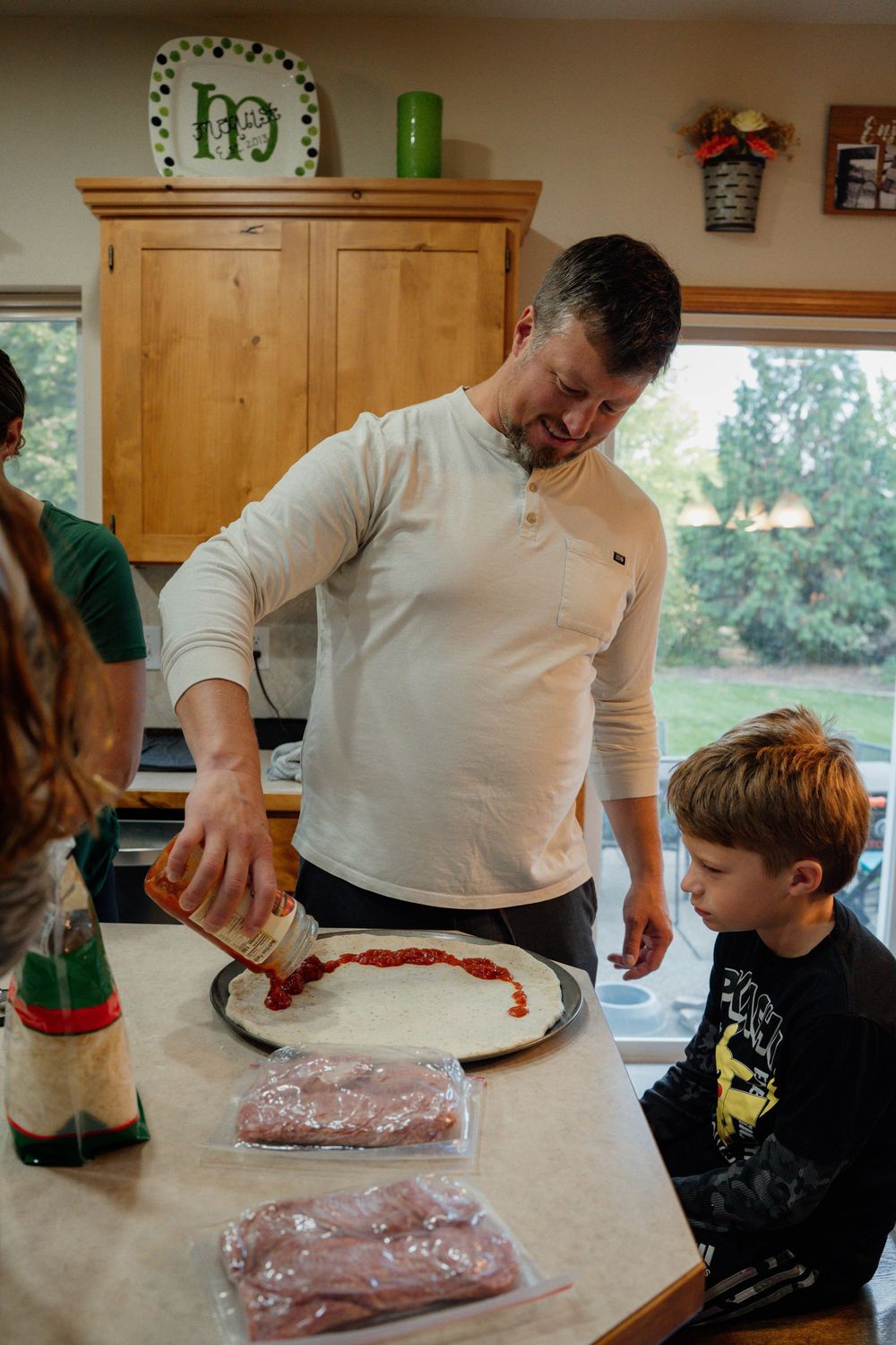 A series of photos showing people preparing food together on a wooden kitchen counter.