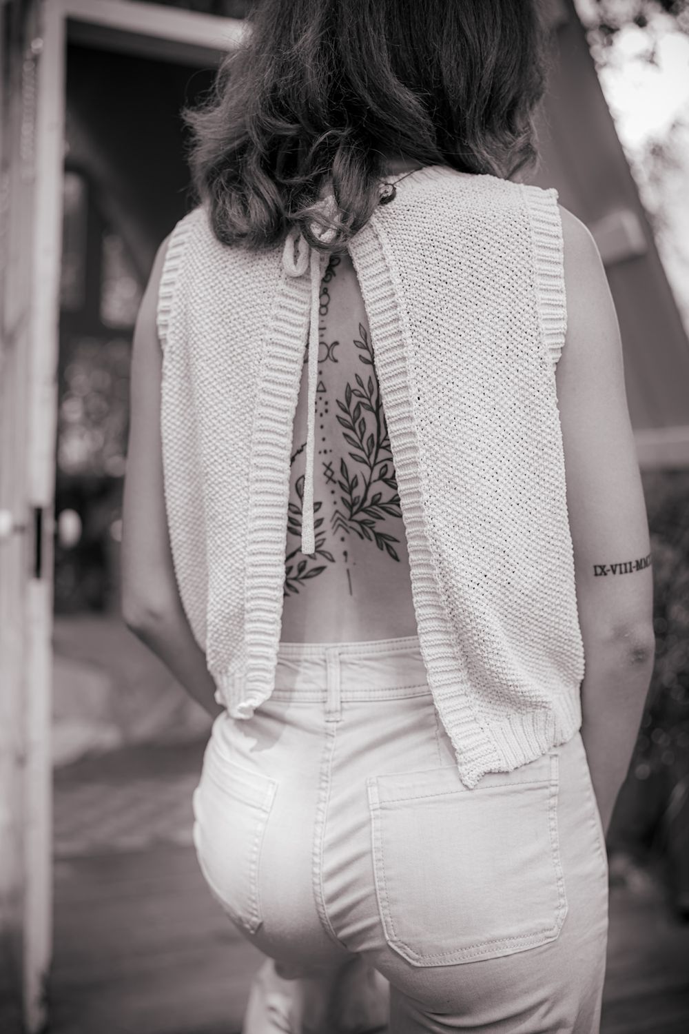 Black and white portrait showing detailed back view of a textured white dress.