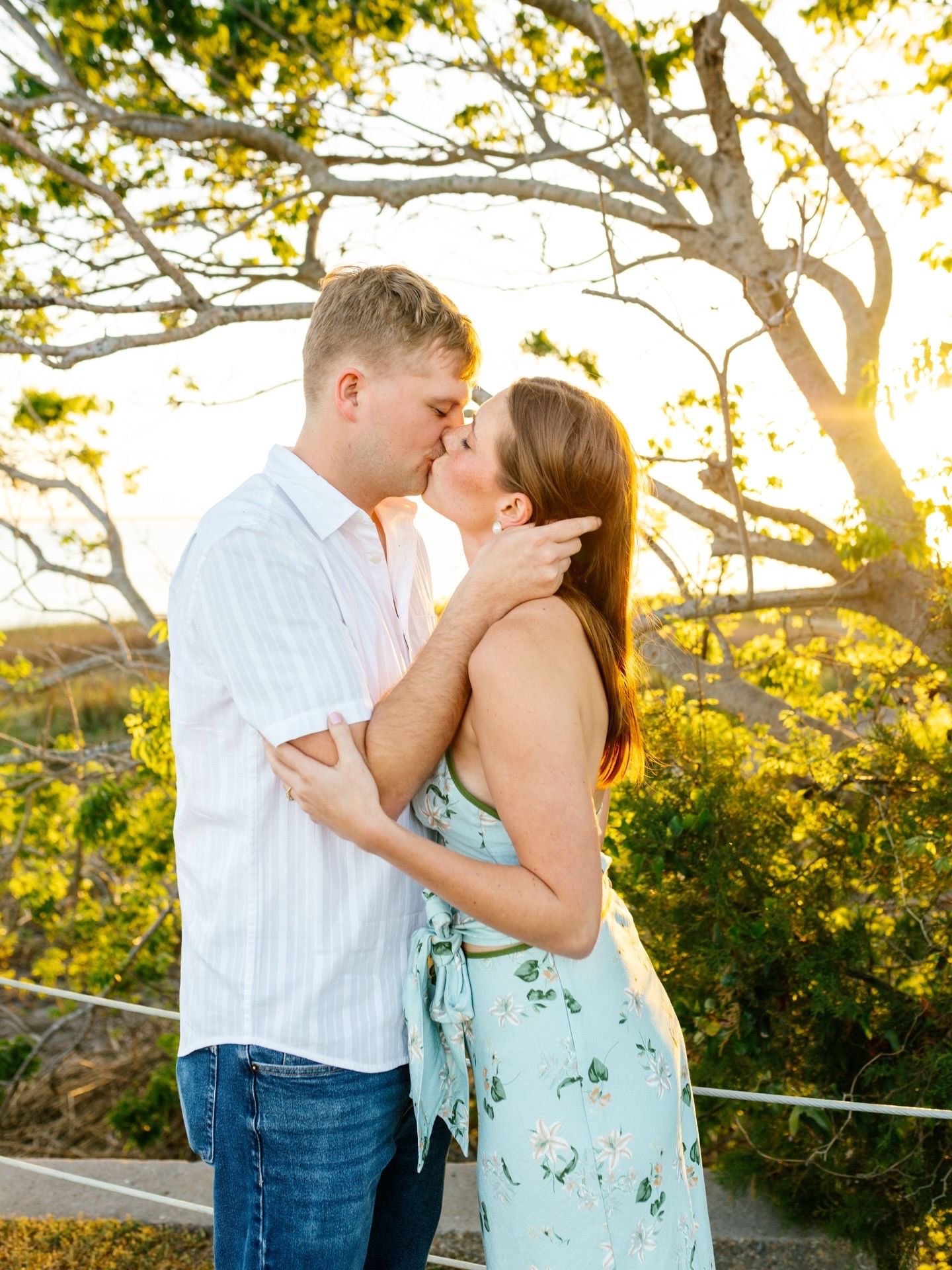 Loving couple sharing intimate moments during sunset beach photoshoot.