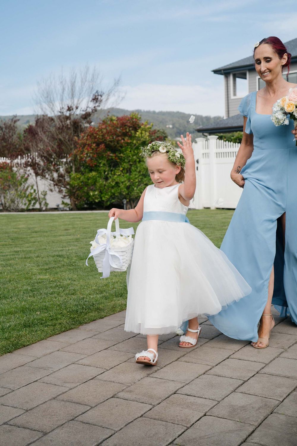 A sequence of photos showing the hem of a white wedding dress next to a light blue bridesmaid dress on stone pavement.