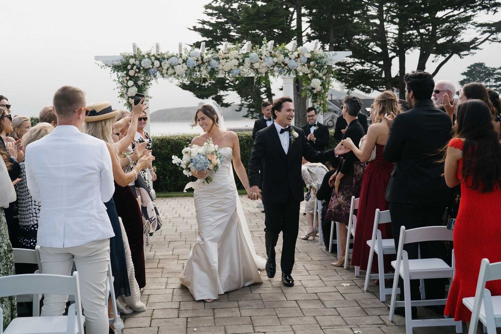 Wedding celebration on an outdoor stone patio with guests and decorative elements.