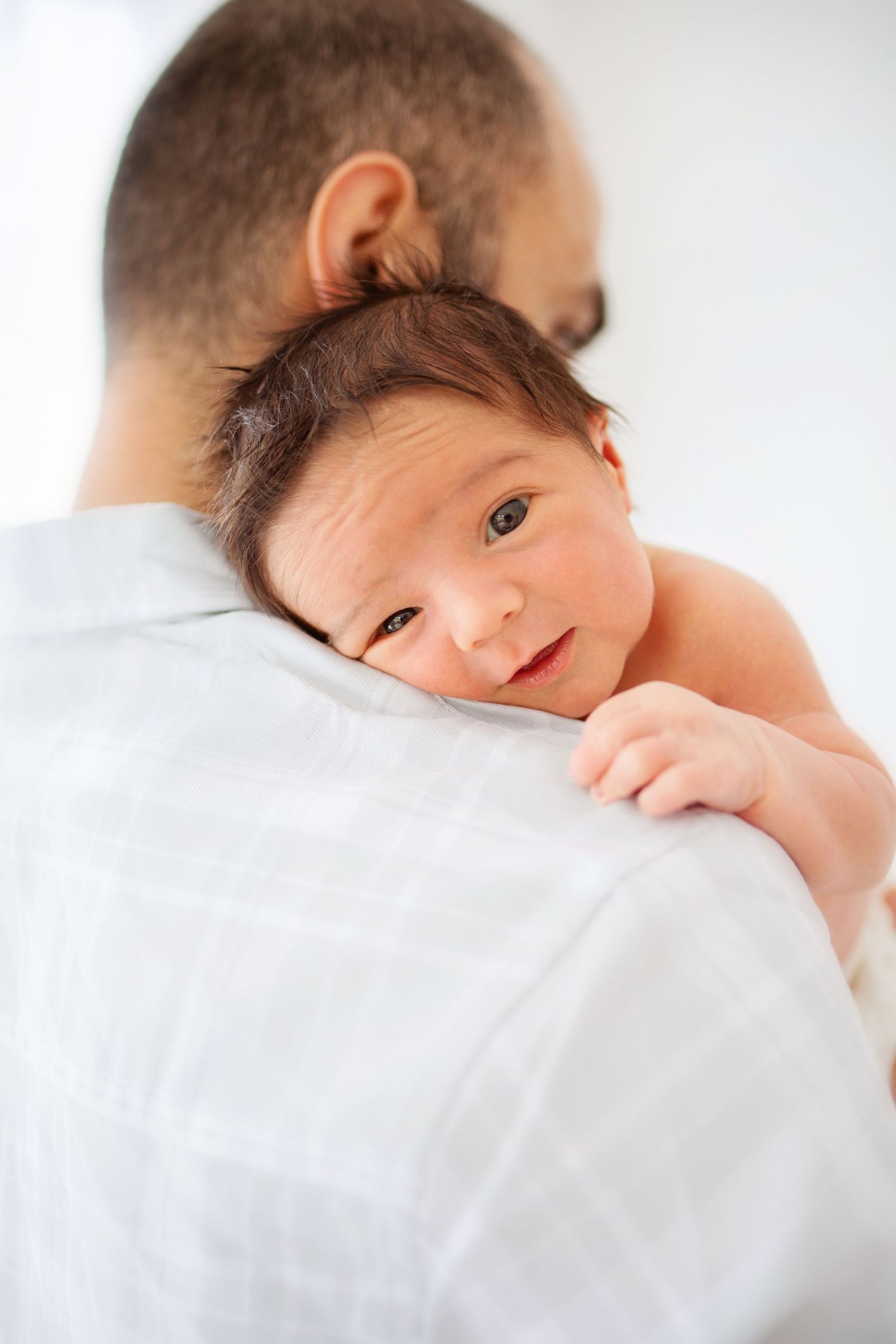 Ett ömt ögonblick mellan förälder och baby på pappas axel