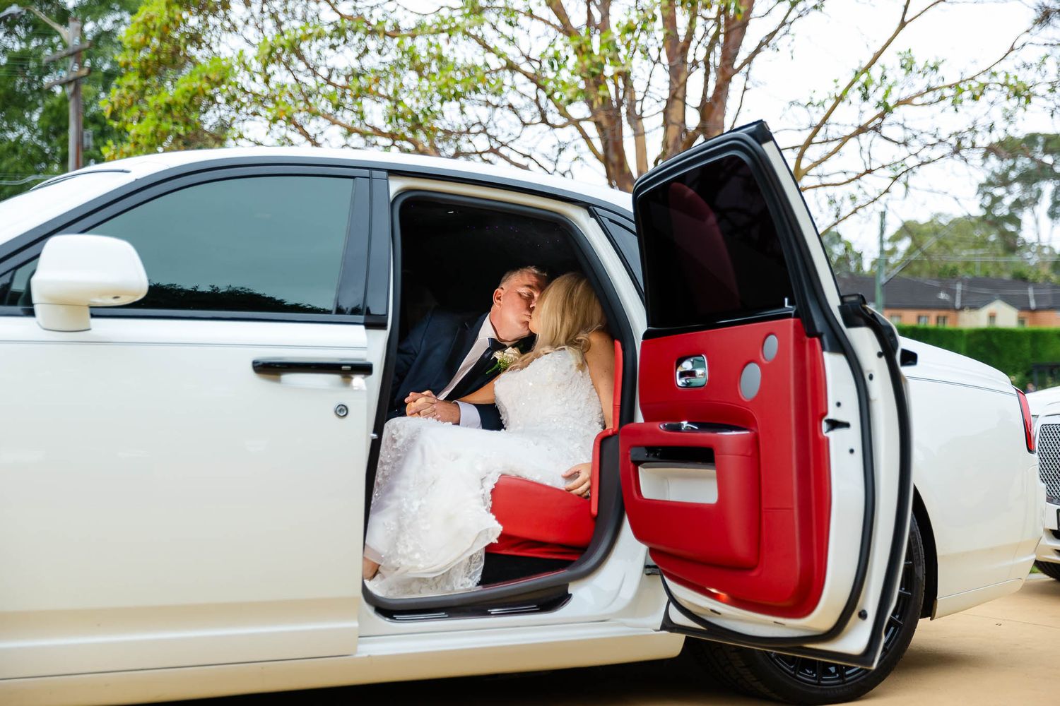 A white Rolls-Royce with red interior is shown from multiple angles with wedding couple seated in the back seat.