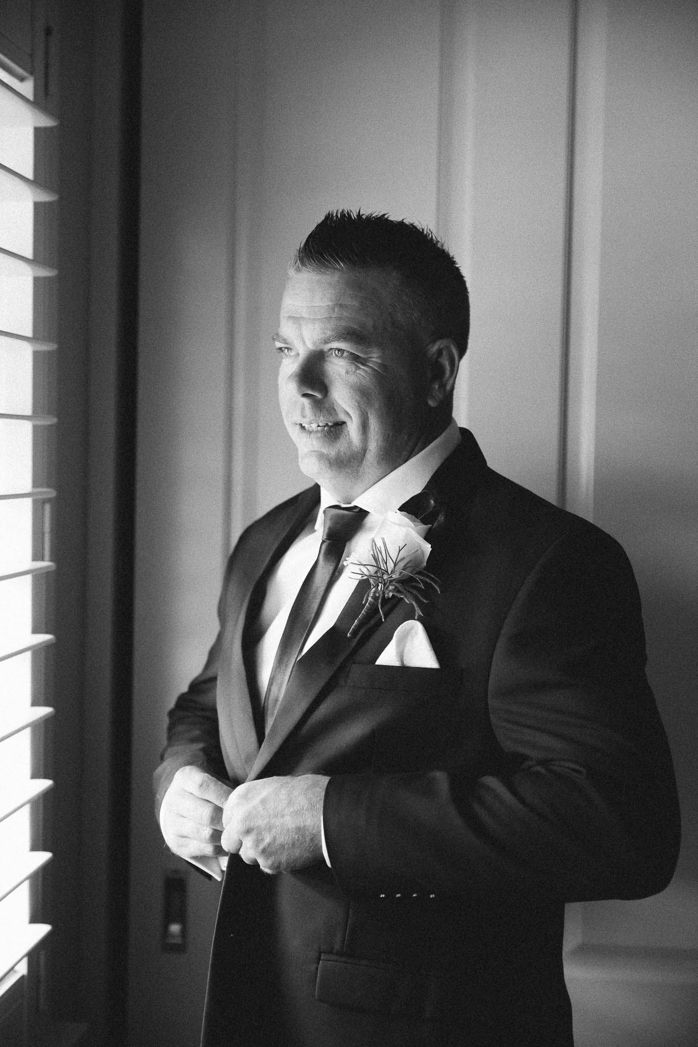 Black and white photo series showing a person in a suit adjusting their tie in three sequential frames.