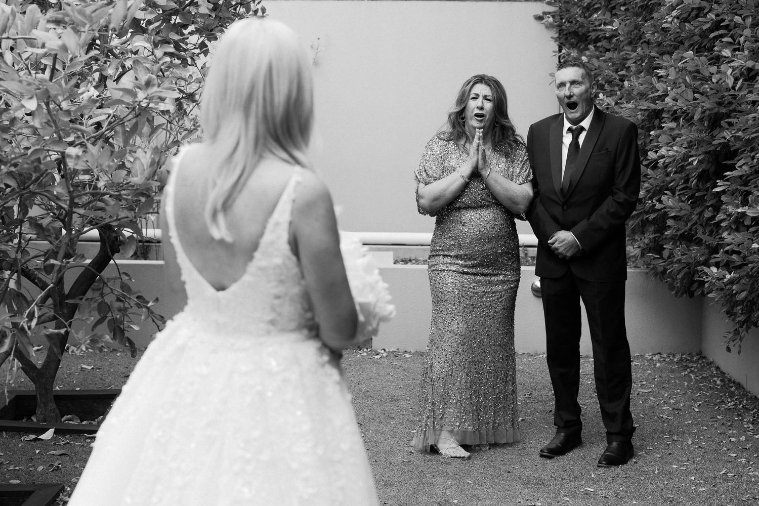 A collection of black and white wedding photos showing moments between couples and family members in outdoor settings.