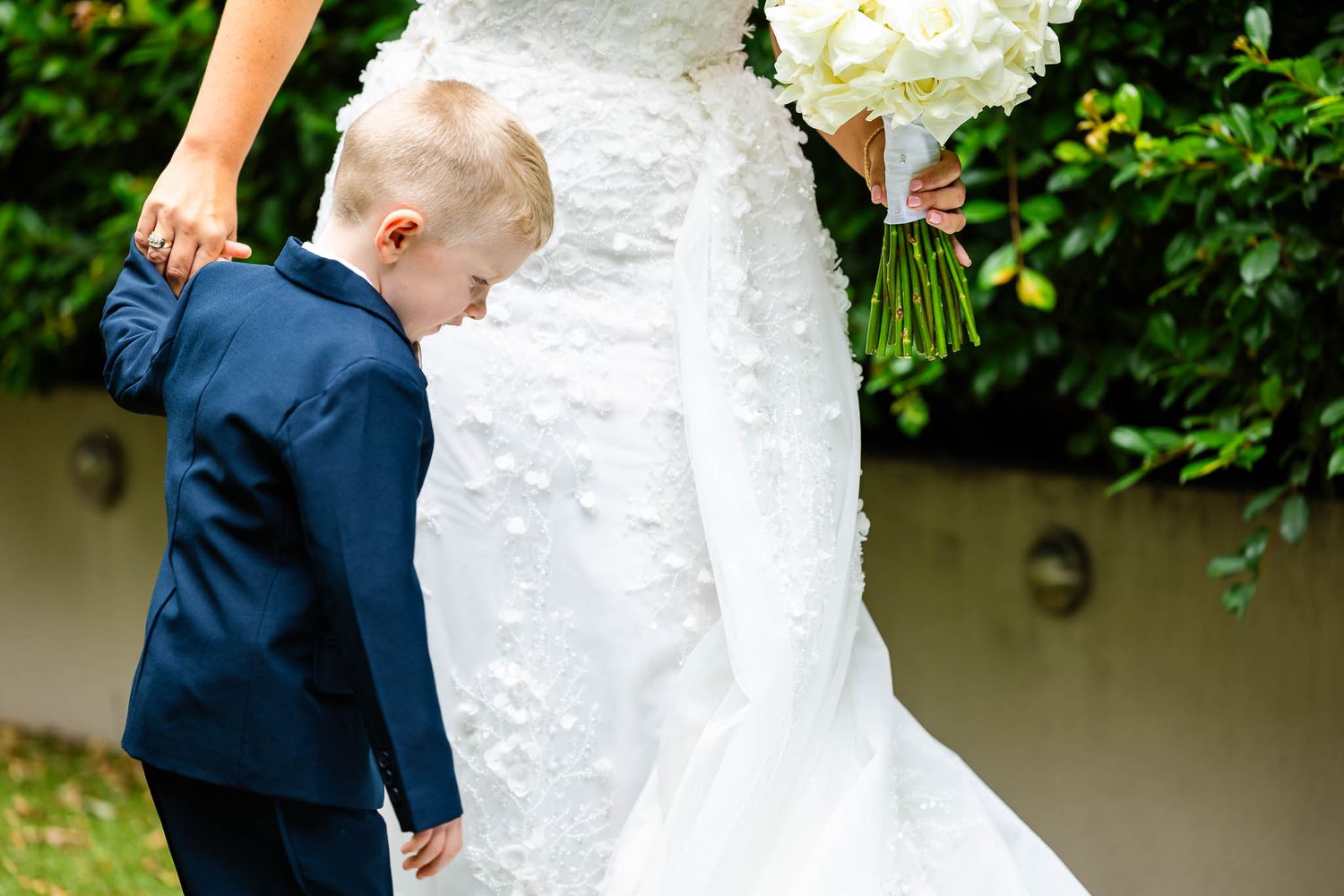 Close-up view of a white wedding dress with intricate lace details and beading.