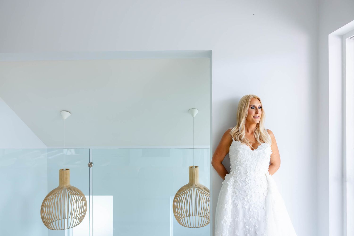 A light and airy interior space features modern pendant lights and white decor with minimalist styling.
