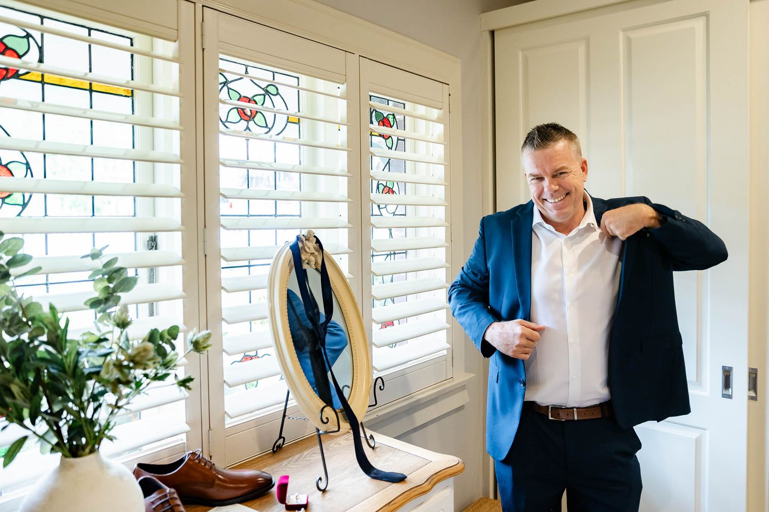 A series of minimalist office scenes showing someone in business attire adjusting their clothing near bright windows.