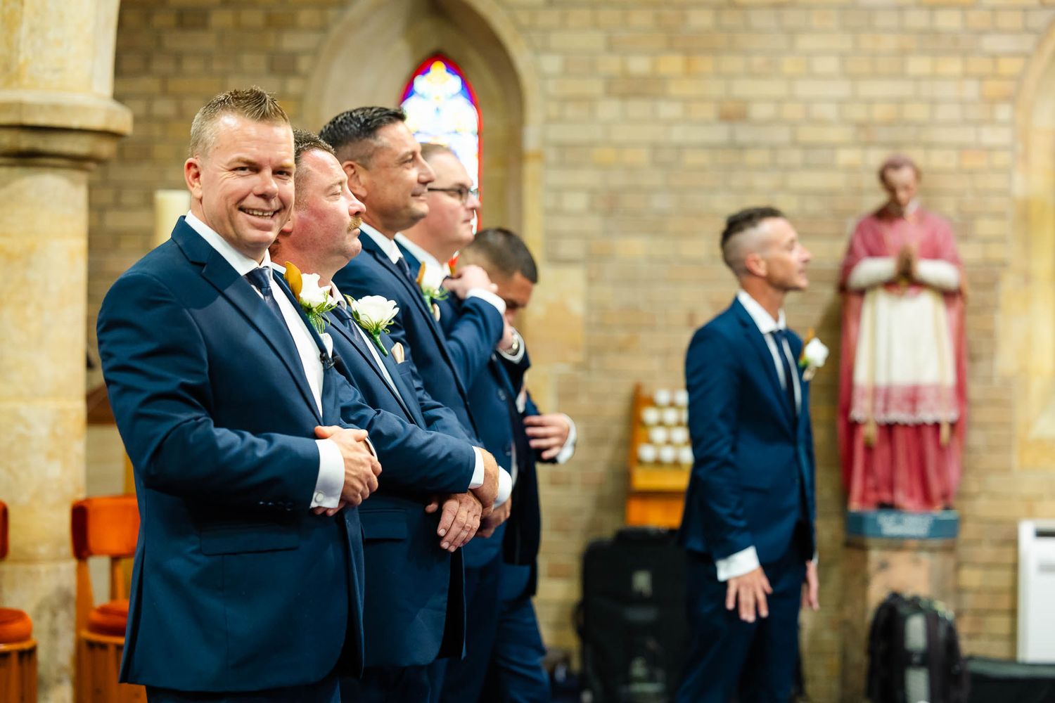 Wedding guests gathered outside a rustic brick church during a celebration.