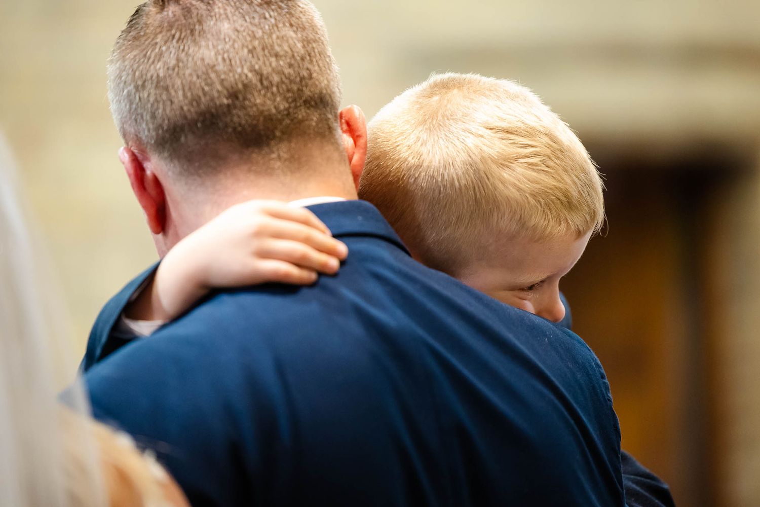 A group of people embracing in an emotional moment during what appears to be a wedding ceremony.