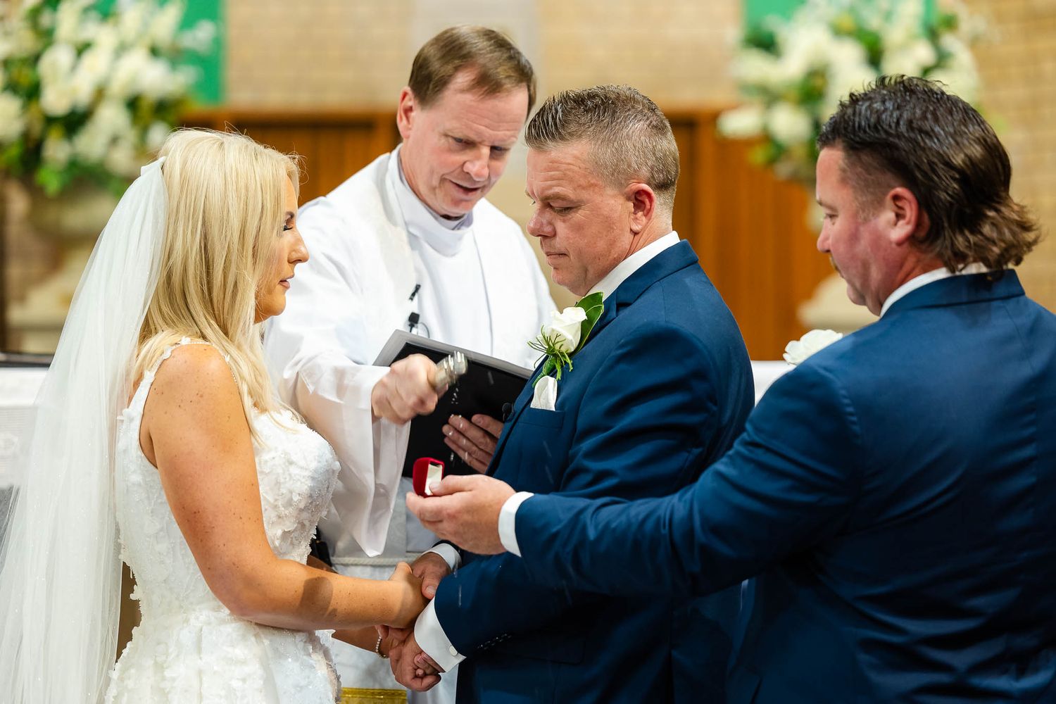 A wedding ceremony takes place in a church with a minister and couple exchanging rings at the altar.