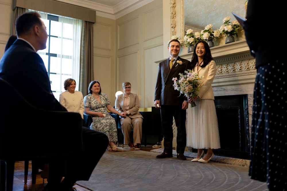A panoramic sequence of wedding ceremony moments captured in an elegant indoor venue with white floral decorations.