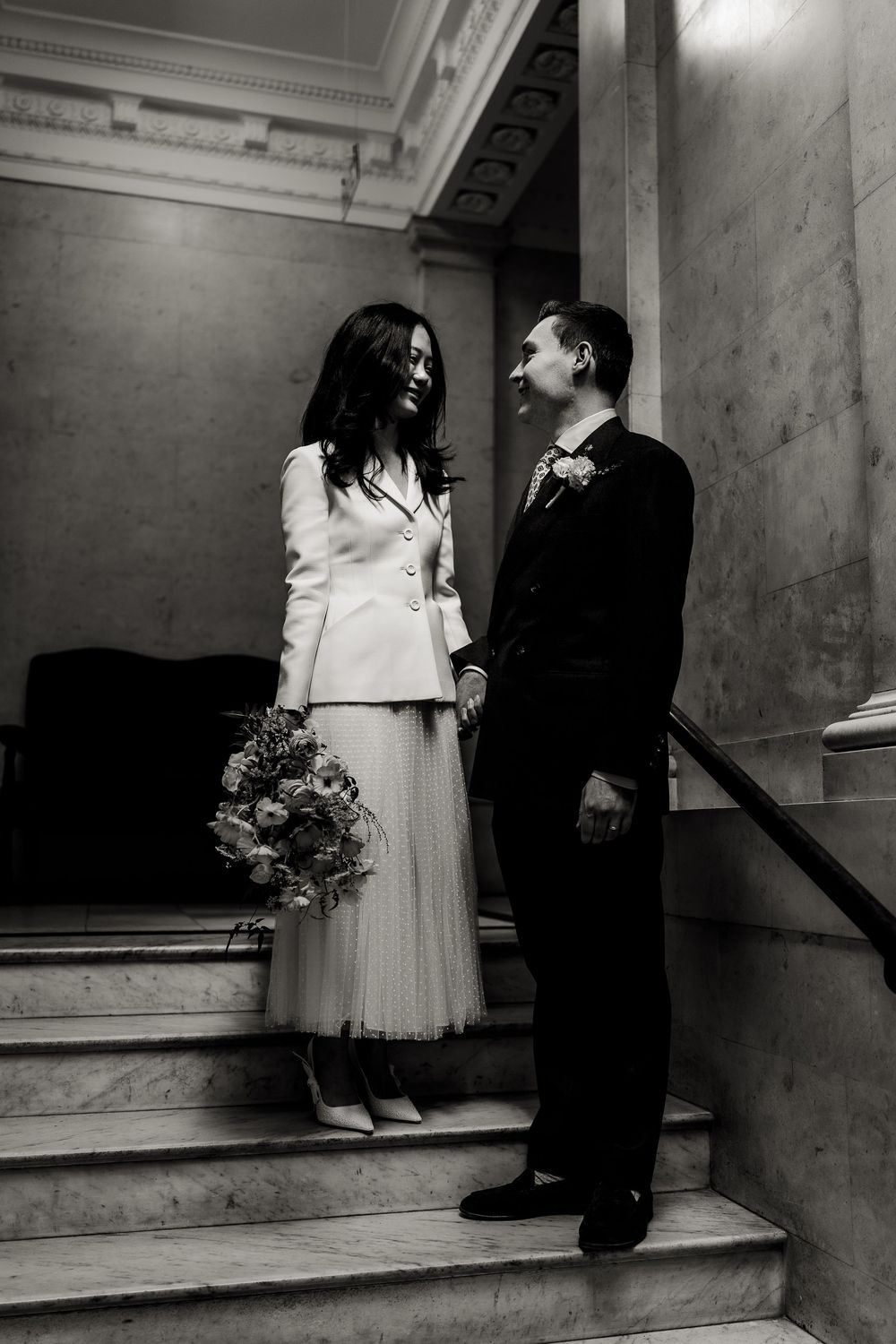 Series of black and white wedding photos showing couple's feet and formal attire on marble steps in elegant setting.
