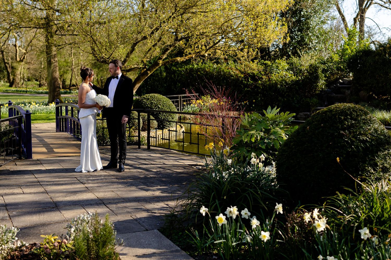 Historic stone manor hotel with classic Georgian architecture and manicured topiary gardens along entrance path.