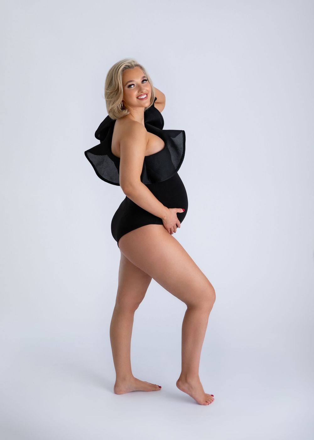 A figure in a black bodysuit poses playfully against a white studio backdrop in a series of dynamic shots.