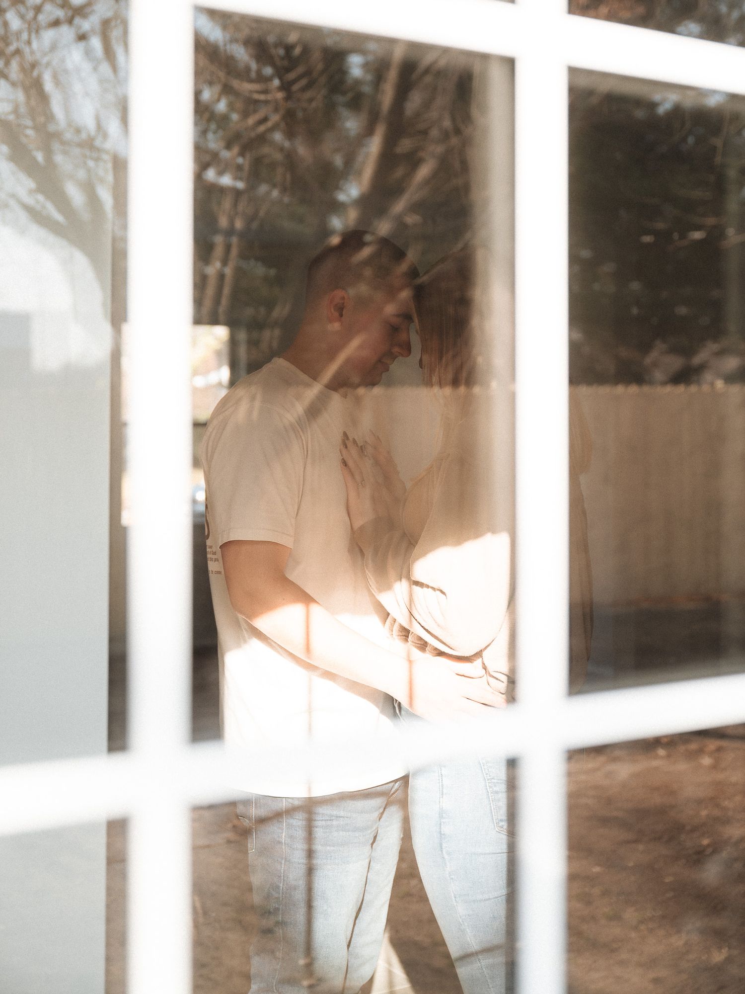 Sunlit silhouette through window panes creating a dreamy atmospheric scene.