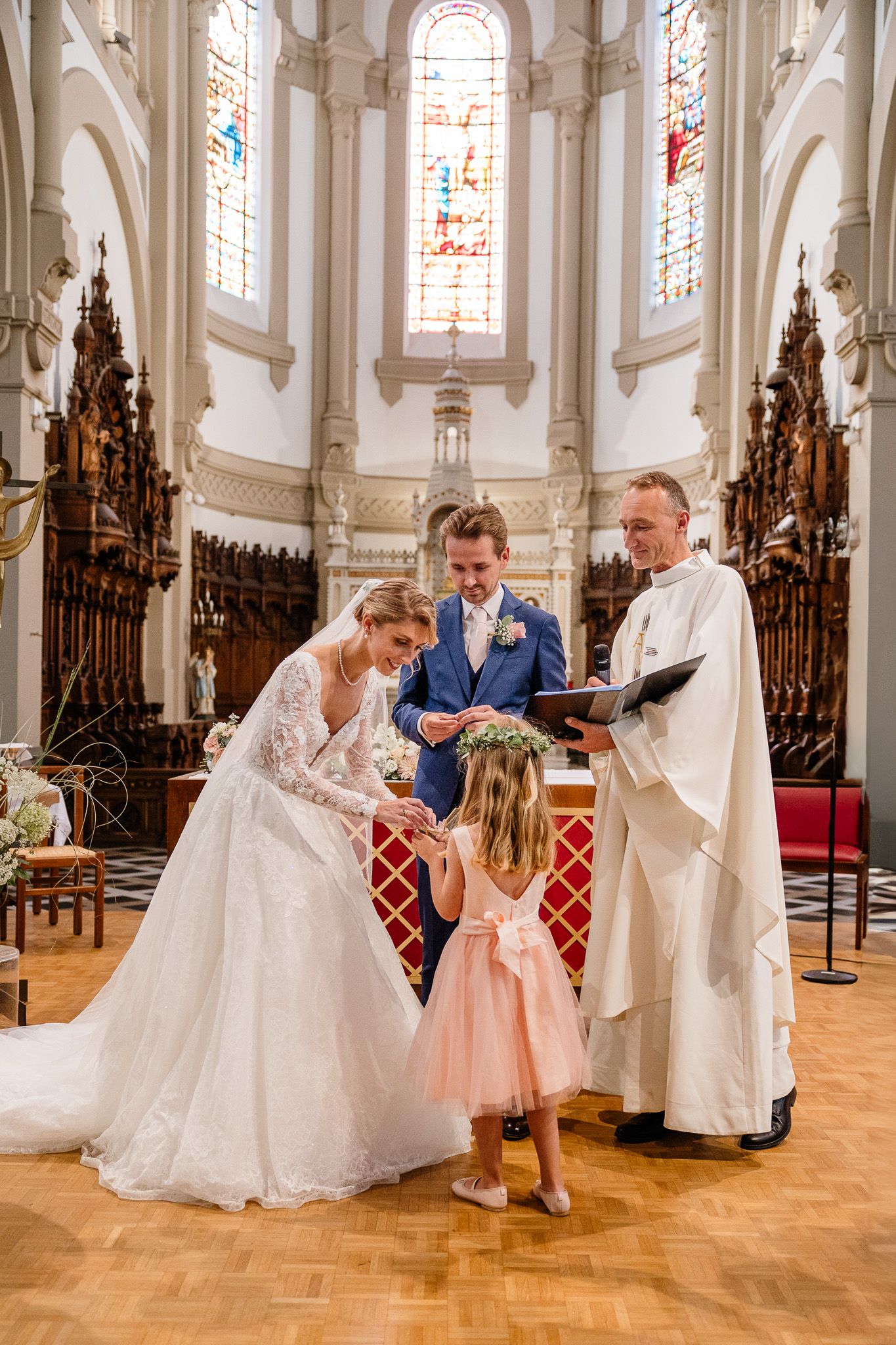 Demoiselle d'honneur apporte les alliances aux maries lors de la ceremonie religieuse, un moment capture pour le reportage photo mariage.