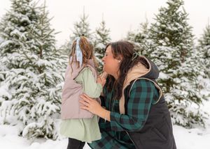 Tender winter photography series showing close interactions in a snowy forest landscape.