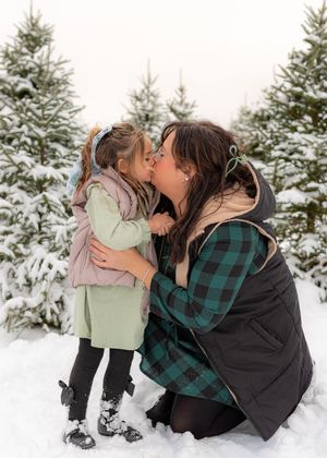 Emotional winter portraits showing affectionate moments among snow-covered evergreens.