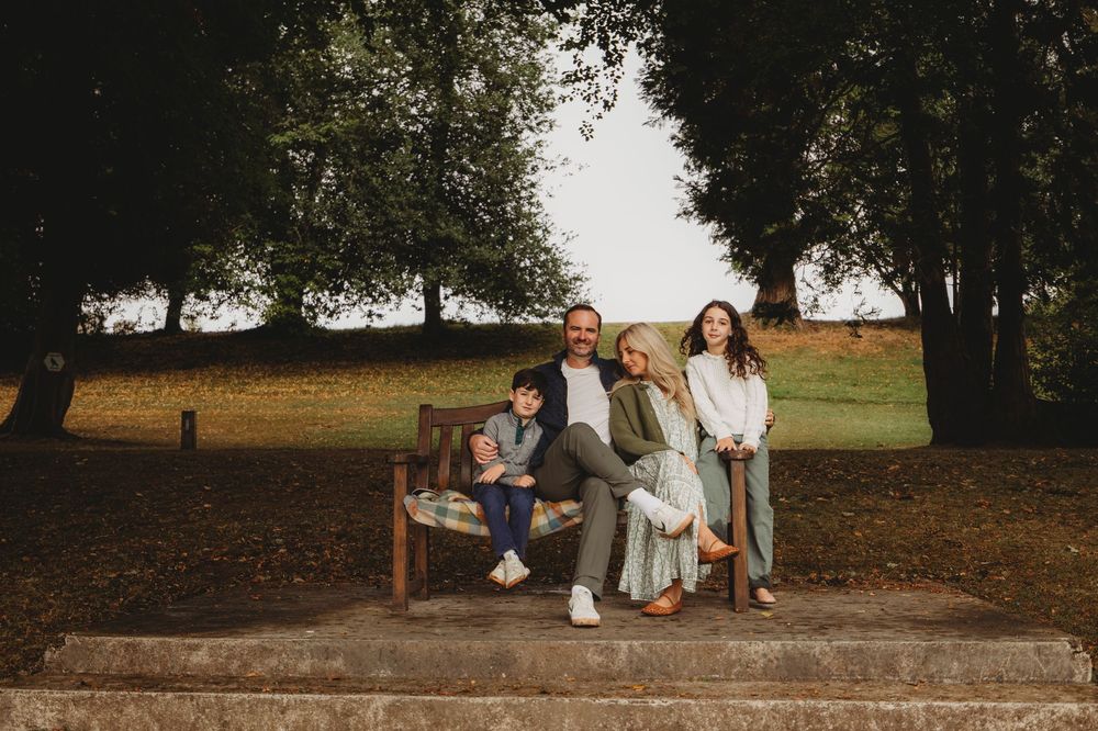 A group of people sitting on stone steps in a park during an outdoor photo session.