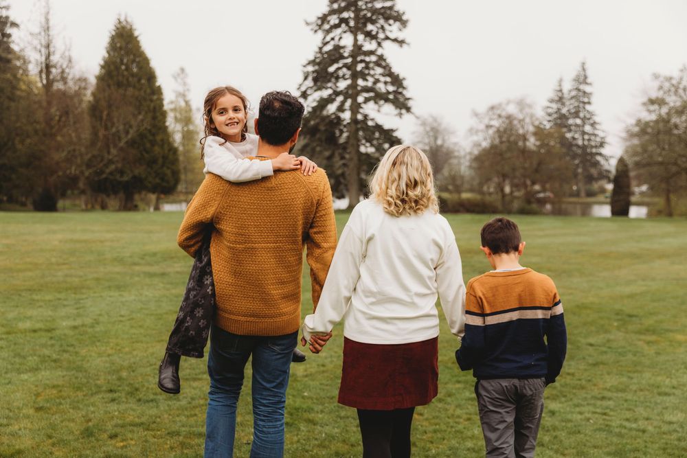 People walking together through a green field on an overcast autumn day.