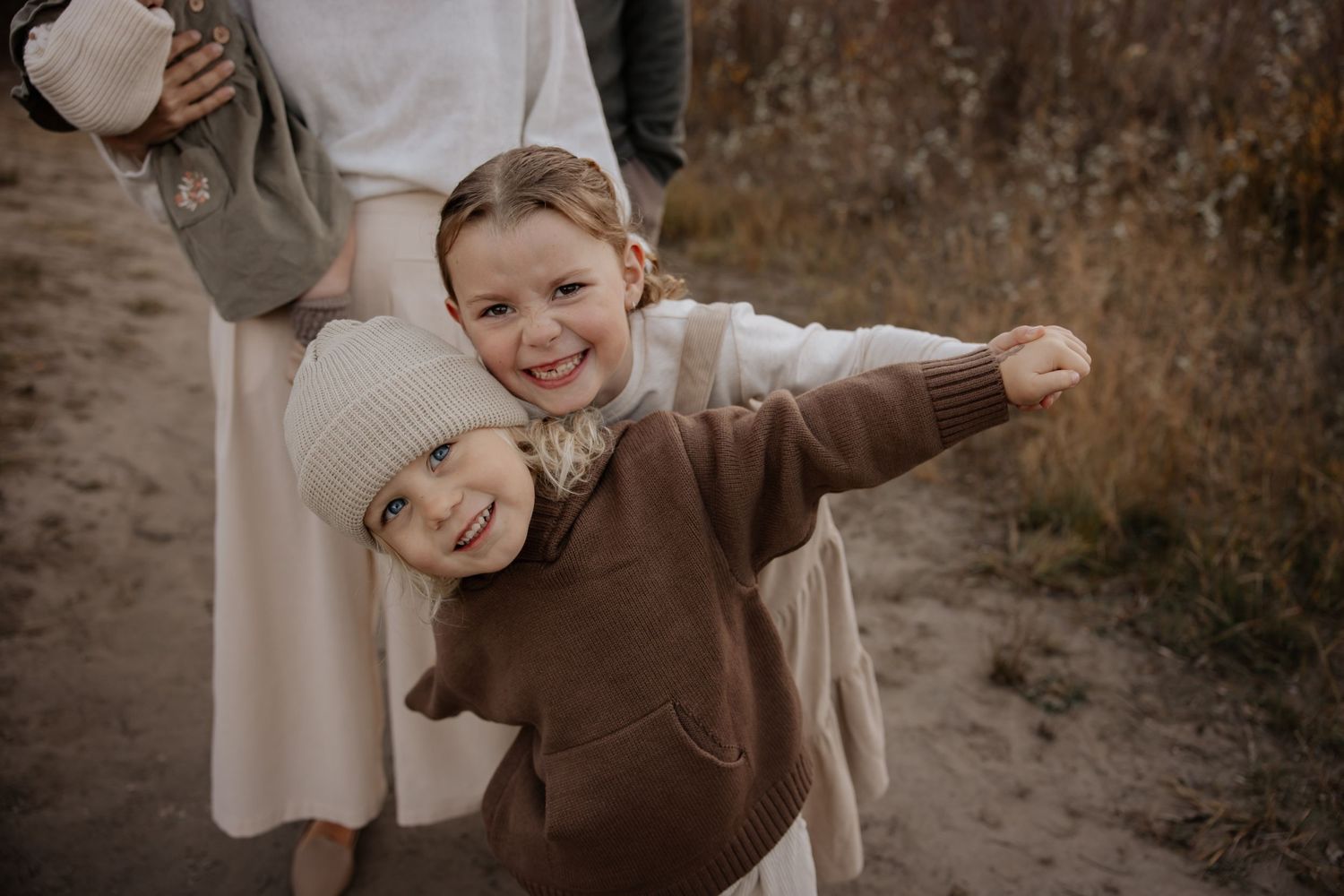 Playful moments captured in earth tones against mountain landscape.