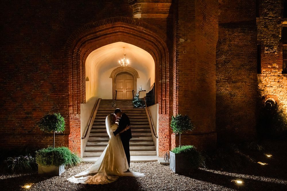 A romantic stone archway illuminated at night creates a warm, inviting entrance to a historic building.