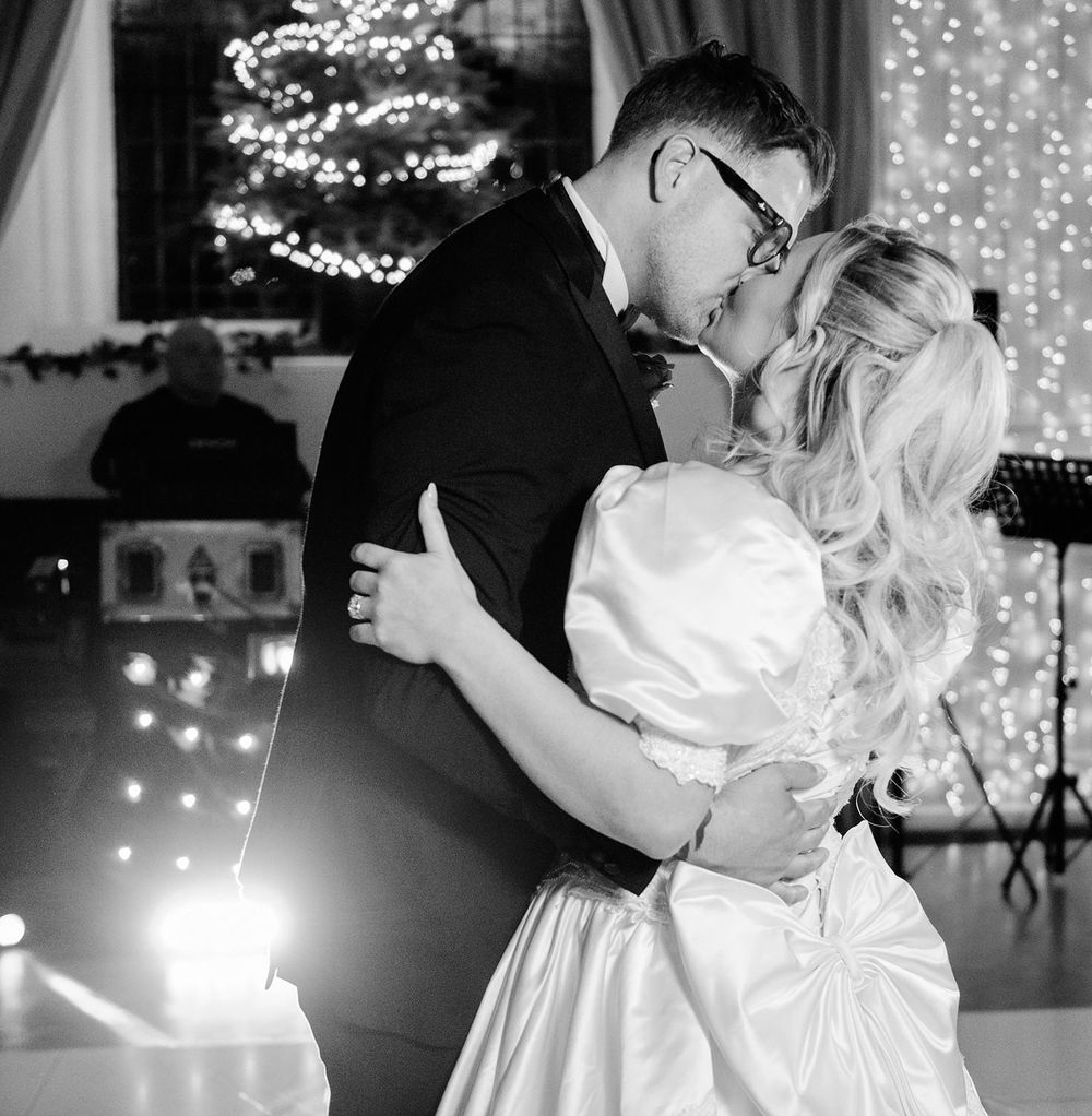 Black and white photo series of a couple dancing at their wedding reception with twinkle lights in the background.