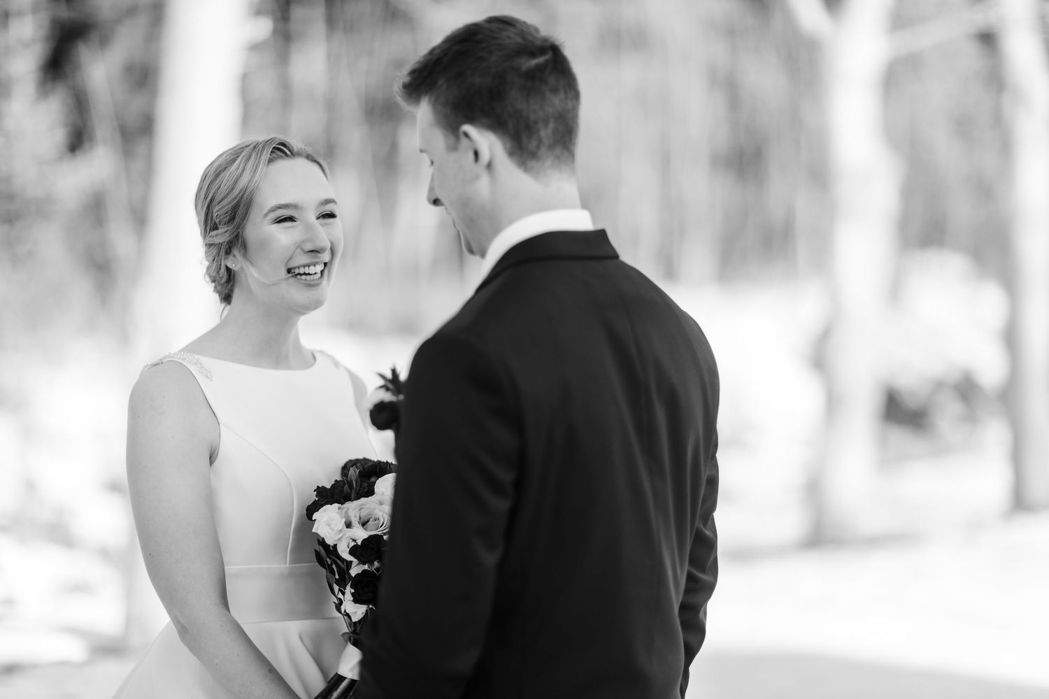 Black and white wedding photos showing joyful moments between a couple and their guests at an outdoor celebration.