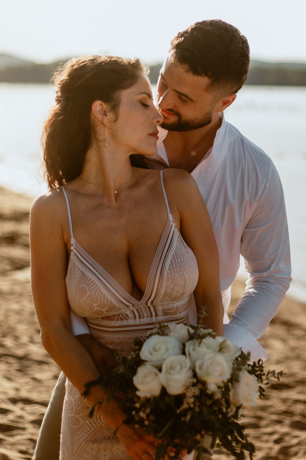 Bride and groom on their wedding day on the beach in Québec, captured in soft natural light by a professional wedding photographer at sunset