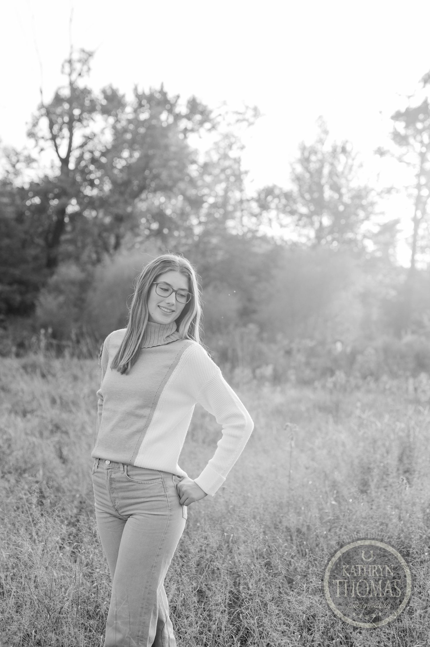 Black and white portrait in casual attire against misty natural background.