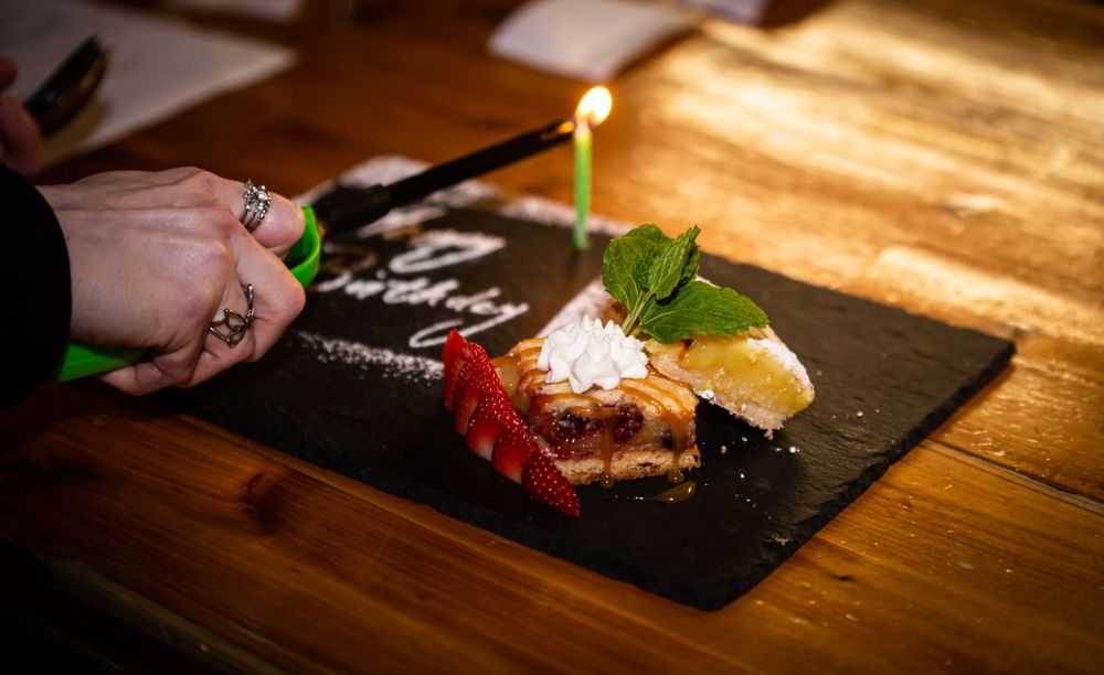 Close-up of elegant plated desserts on dark slate plates with artistic presentation.