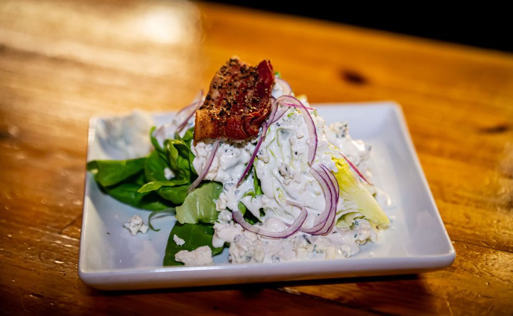Fresh salads and appetizers plated on white dishes with colorful garnishes.