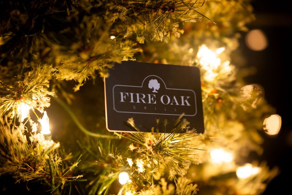 Illuminated restaurant sign with decorative holiday lights creating warm ambiance.