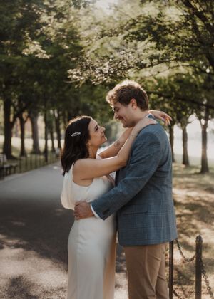 Romantic moment captured on tree-lined path during golden hour.